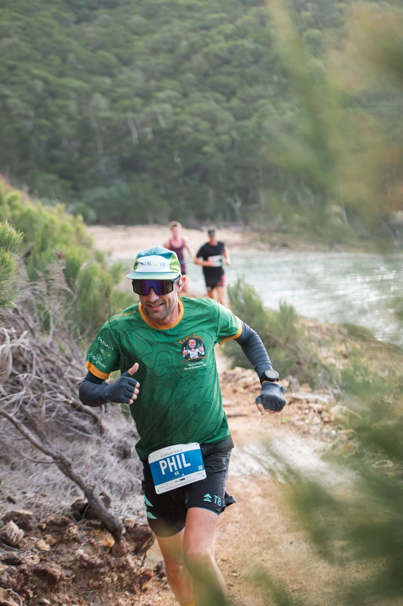Phil Gore running in Team Gore kit on a coastal trail